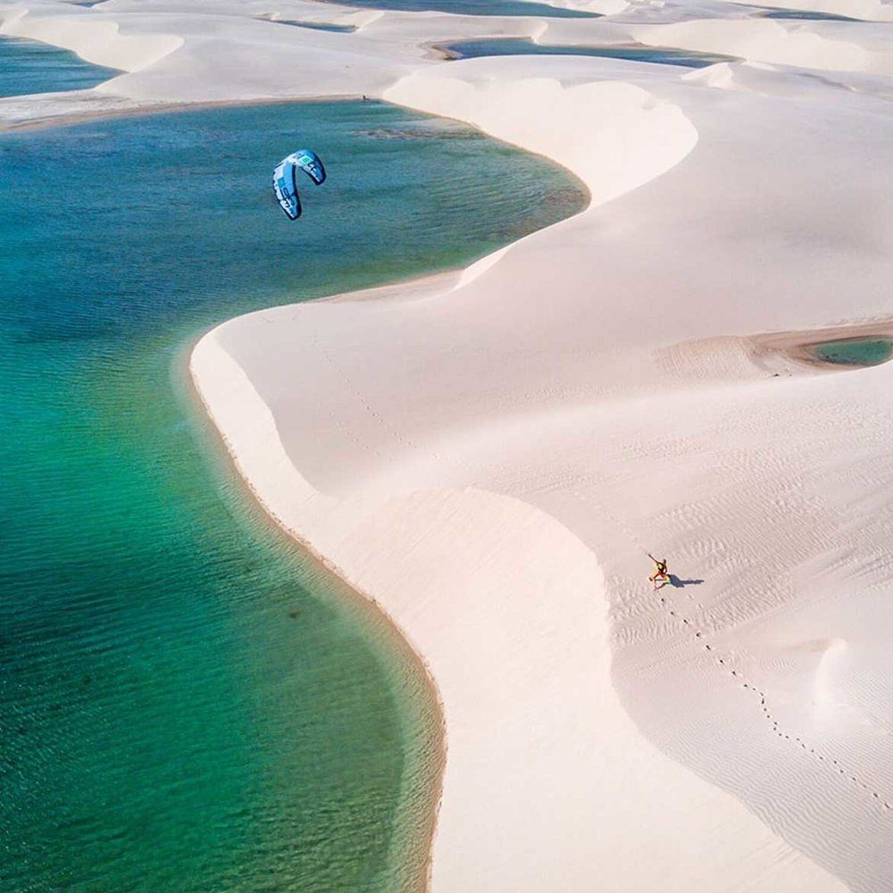 Kitesurfer sailing in Lençóis Maranhenses during an exclusive downwind kitesurfing experience in Northeast Brazil, highlighting the best routes and conditions for kitesurfers.